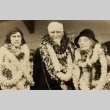 A man and two women wearing leis (ddr-njpa-1-405)