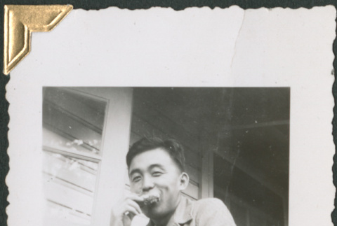 Man sitting on porch eating (ddr-densho-434-154)