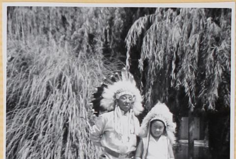 Susan Shiomi in costume headdress with actor wearing indigenous costume (ddr-densho-522-595)