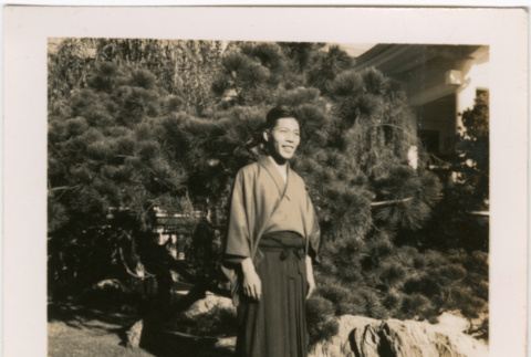 Man standing in garden by large rock (ddr-densho-426-2073)
