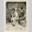 Photo of Gloria Kusano Kubota wearing overalls in garden (ddr-densho-122-629)