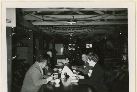 Diners in a mess hall decorated for Christmas (ddr-densho-37-1299)