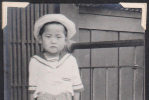 Boy in sailor suit with hat in front of building (ddr-densho-468-485)