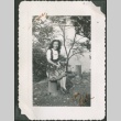 A woman sitting on a tree stump (ddr-densho-328-268)