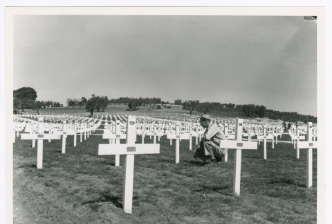 Pfc. Elmer L. Marcum kneeling at grave of Sgt. Kiyoshi Iguchi (ddr-densho-1007-170)