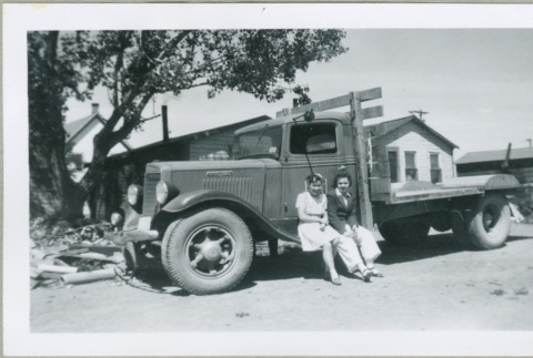 Two women sitting on a truck (ddr-densho-300-95)