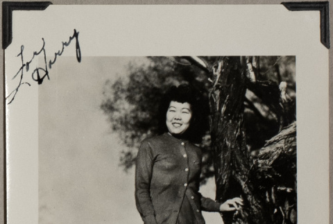 Woman standing by tree trunk (ddr-densho-587-49)