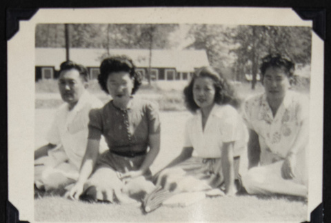 Four people seated on grass (ddr-densho-542-709)
