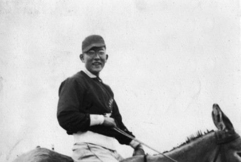 Toshio Kono riding a donkey (ddr-ajah-6-340)