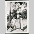 Photo of a man walking with two children (ddr-densho-483-771)