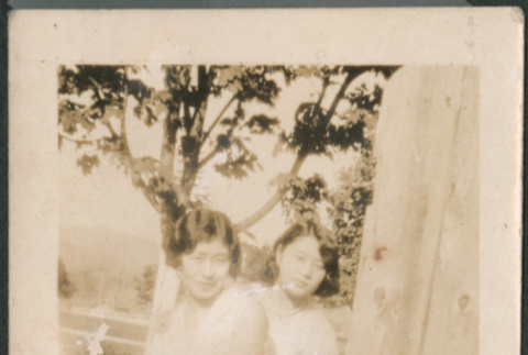Two women sitting on fence (ddr-densho-523-18)