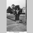 Marge Kajiwara standing on sidewalk carrying books (ddr-ajah-6-70)