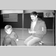 Man with child on gym floor (ddr-densho-1007-1260)