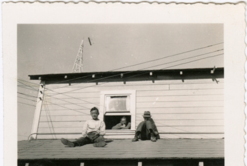 Three men on roof of house, one man on ground looking up (ddr-densho-458-22)