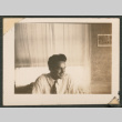 Smiling man in front of a window (ddr-densho-433-781)