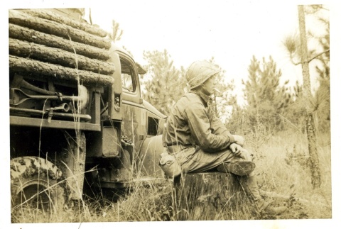 Soldier smoking on a tree stump (ddr-densho-22-204)