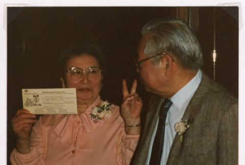 Takeo and Mitzi Isoshima posing with tickets (ddr-densho-477-591)