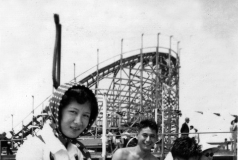 Group on beach with roller coaster in background (ddr-ajah-6-966)