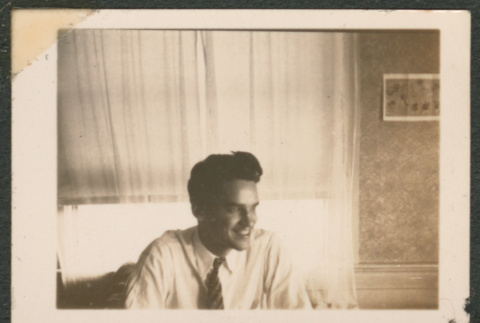 Smiling man in front of a window (ddr-densho-433-781)