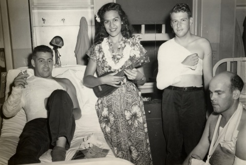 Miss Hawaii playing a ukelele for three wounded soldiers (ddr-njpa-2-851)