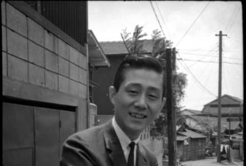 Man in suit with hand on car door (ddr-densho-426-2287)