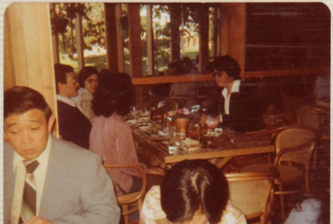 Four people sitting at a table, two people at a table in foreground (ddr-densho-426-1326)
