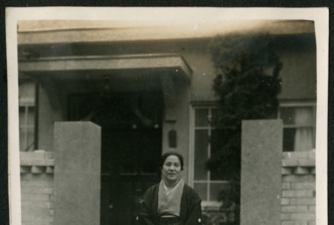Woman poses by front gate (ddr-densho-359-847)
