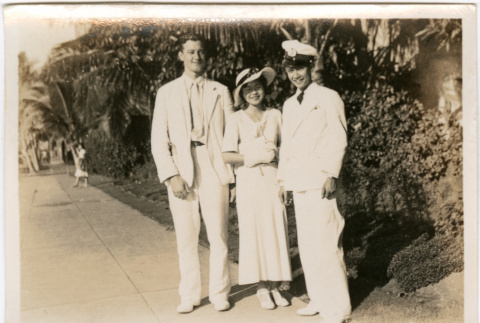 Tomoye (Nozawa) Takahashi standing with two men (ddr-densho-426-1525)