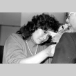 Woman pinning flower onto jacket (ddr-densho-1007-549)
