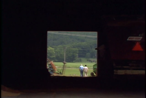 William Kochiyama and Robert H. Foote walking through a Cornell university barn and driving around (ddr-densho-1007-1520)