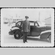 Man standing by car in snow (ddr-densho-434-379)