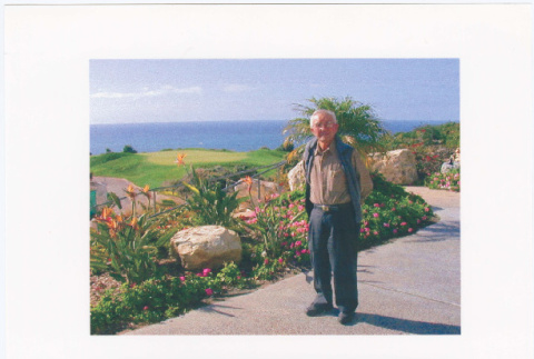 Man standing in garden overlooking ocean (ddr-densho-393-21)