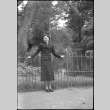 Tomoye (Nozawa) Takahashi standing by metal fence (ddr-densho-426-2179)