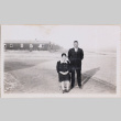 Man and woman posing with barracks in background (ddr-densho-464-125)