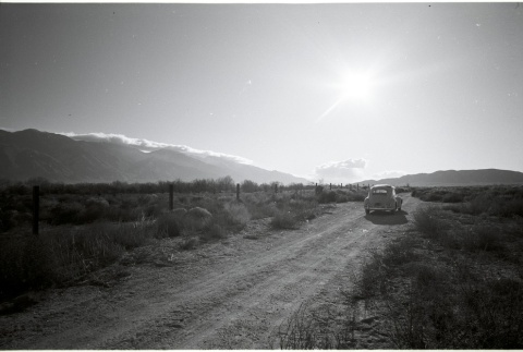 Car driving away from Manzanar (ddr-manz-3-53)