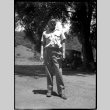 Man standing in front of tree and car (ddr-densho-475-75)