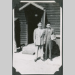 Two men in suits outside camp building (ddr-ajah-2-540)