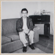 Hardy Shiomi sitting on couch (ddr-densho-522-293)