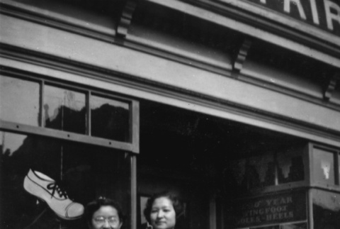Two women and girl outside shoe repair shop (ddr-ajah-6-377)