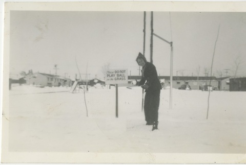 Woman holding a snowball next to a sign (ddr-manz-7-101)