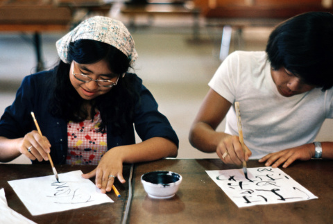 Two campers participating in a calligraphy interest group (ddr-densho-336-342)