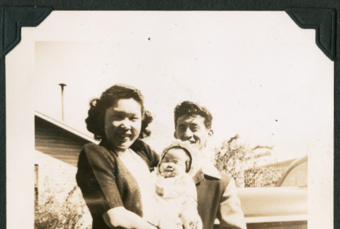 A smiling couple holds a baby (ddr-densho-390-87)