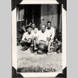 Four men sitting outside barracks (ddr-densho-587-25)