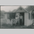 Agnes Sakura with two boys in door of cabin (ddr-densho-523-242)