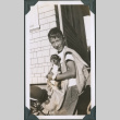 Photo of Paul Ima holding a dog in a news sack (ddr-densho-483-1229)
