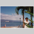 Tomi Iino on beach in front of Queen Elizabeth cruise ship (ddr-densho-368-297)