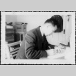 Man sitting at desk writing (ddr-densho-434-378)
