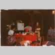 Tomoye and Henri Takahashi standing by table with gifts (ddr-densho-426-1294)