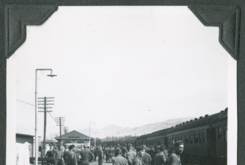 Men in uniform standing alongside train tracks and train (ddr-ajah-2-270)