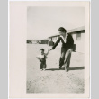 Sally Domoto walking with toddler outside barracks (ddr-densho-329-1339)